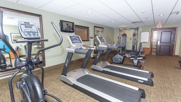 A gym with treadmills, elliptical machines, and exercise equipment.