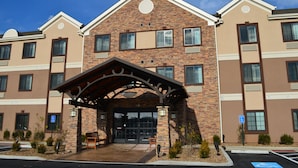 A multi-story hotel with a brick facade, large windows, and a covered entrance.