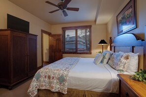 A bedroom with a bed, a ceiling fan, a window with blinds, a nightstand, and a wooden wardrobe. - TL2111 | Nice Ground Floor Condo | Winter Shuttle | Close to Slopes | Hot Tubs (Steamboat Springs)