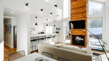 A modern interior with a kitchen, dining area, and a fireplace.