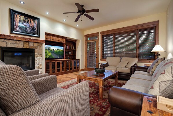 A living room with a fireplace, television, and seating area. - EL5107 | Private Patio with Hot Tub | Air Chilling | Close to Skiing | 4 Pools (Steamboat Springs)