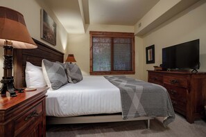 A bedroom with a bed, a television, a dresser, and a window with blinds. - EL5107 | Private Patio with Hot Tub | Air Chilling | Close to Skiing | 4 Pools (Steamboat Springs)