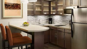 A modern kitchen with a built-in island, stainless steel appliances, and a tiled backsplash.