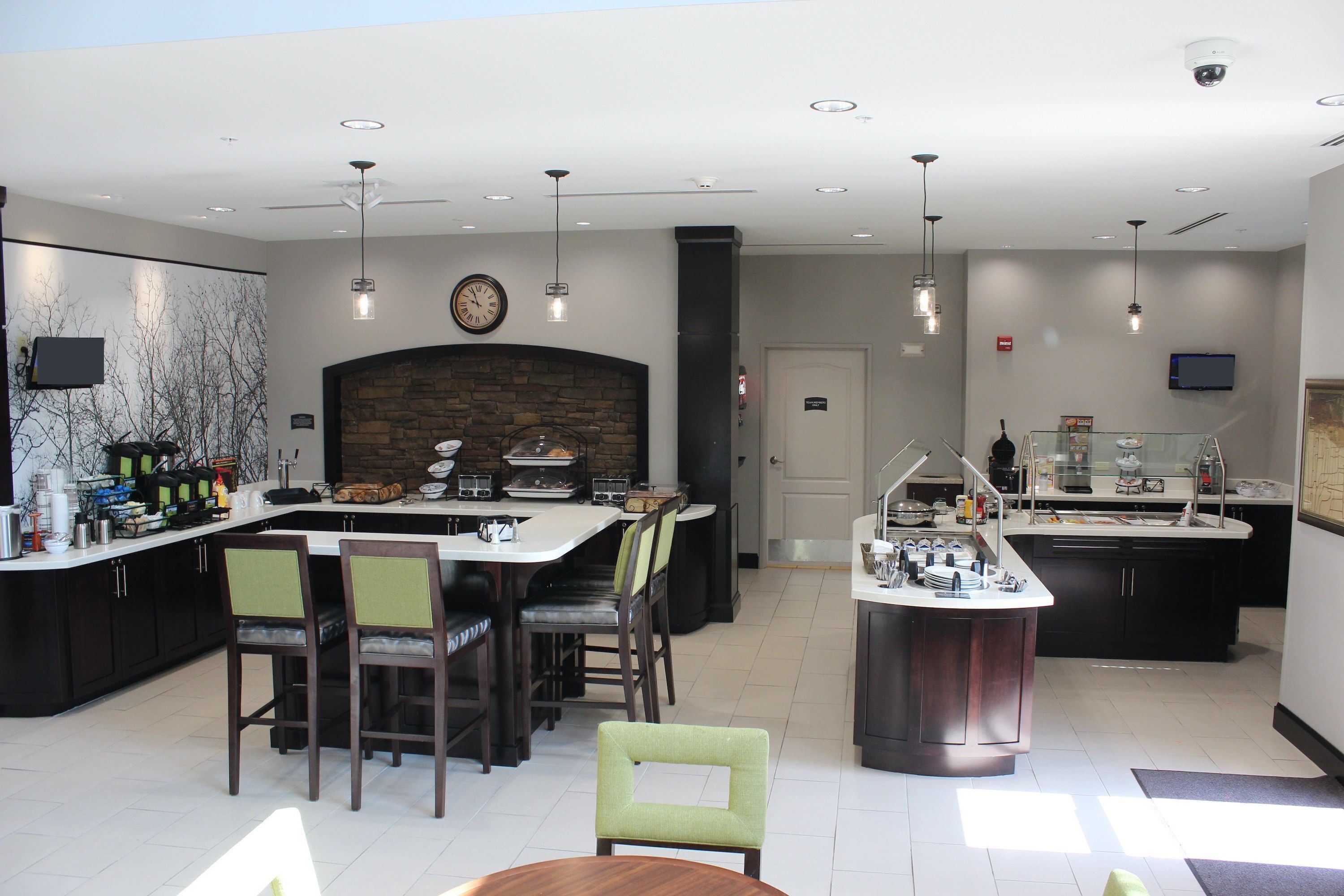 A modern kitchen with a central island, bar area, and seating.