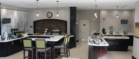 A modern kitchen with a central island, bar area, and seating.