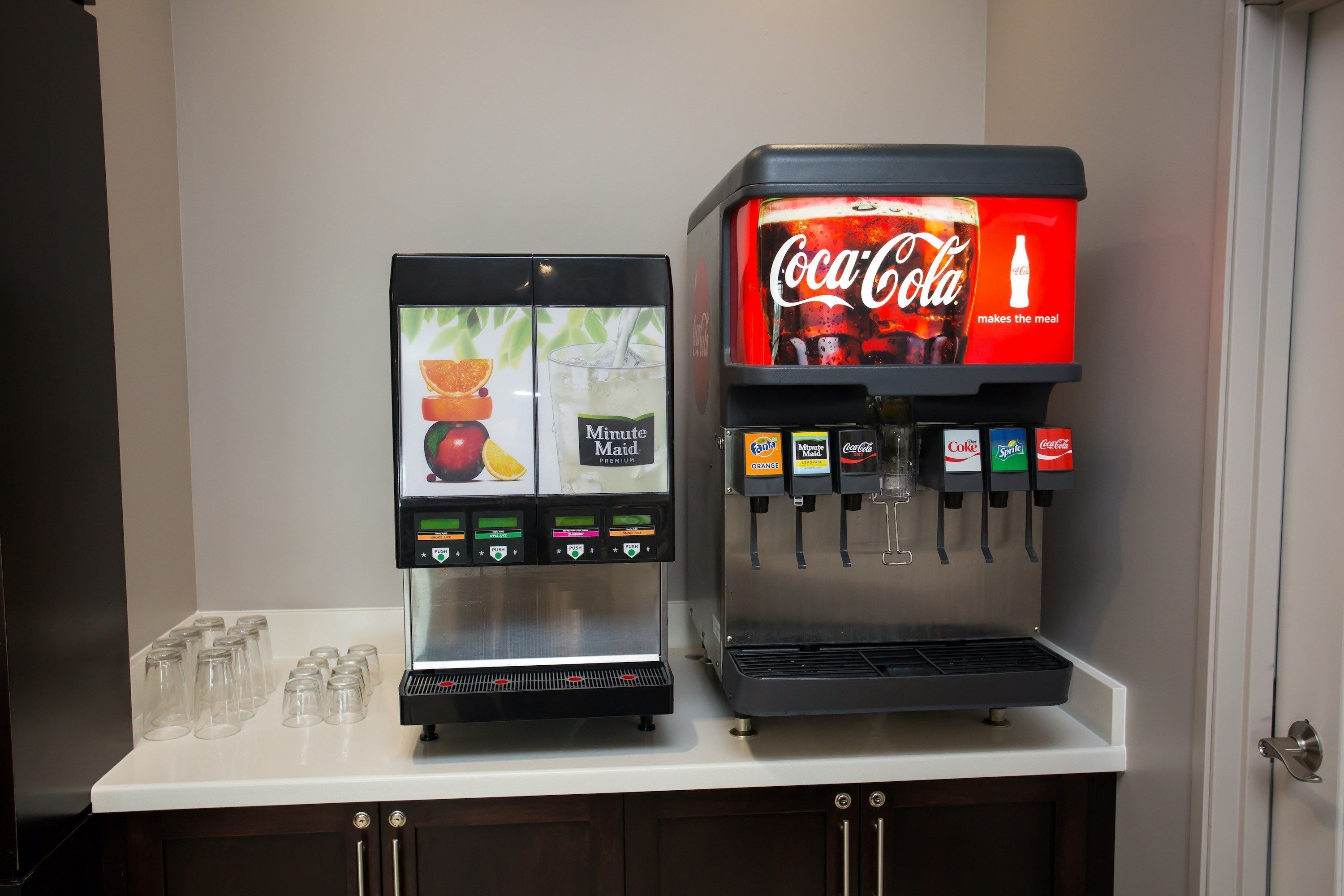 A beverage vending machine with options for Minute Maid juice and Coca-Cola, and a separate juice dispenser.