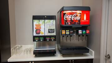 A beverage vending machine with options for Minute Maid juice and Coca-Cola, and a separate juice dispenser.