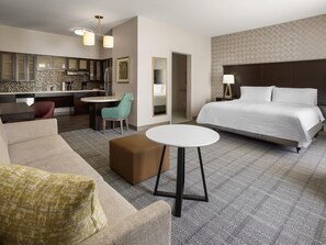 A hotel room with a bed, a sofa, a small table, a kitchenette, and a bathroom. - Accessible King Studio w/ Tub | Free Breakfast! (Miamisburg)