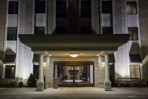 A hotel entrance with a large overhang, columns, and a sign reading "1010". - Accessible King Studio w/ Tub | Free Breakfast! (Miamisburg)