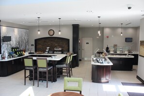 A modern kitchen with a central island, bar area, and seating.