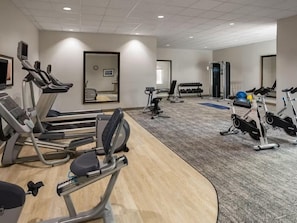 A gym with treadmills, elliptical machines, and weightlifting equipment.