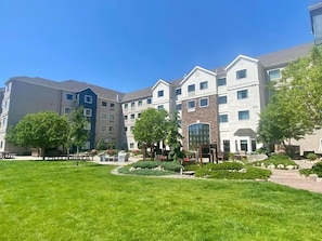 A multi-story residential building with a well-maintained lawn and trees. - Missouri River View Suite | Free Breakfast! (Great Falls)