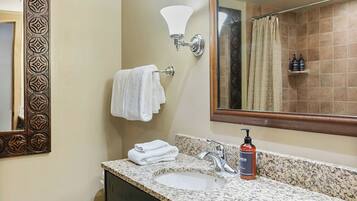 A bathroom with a sink, mirror, towel rack, and shower curtain.