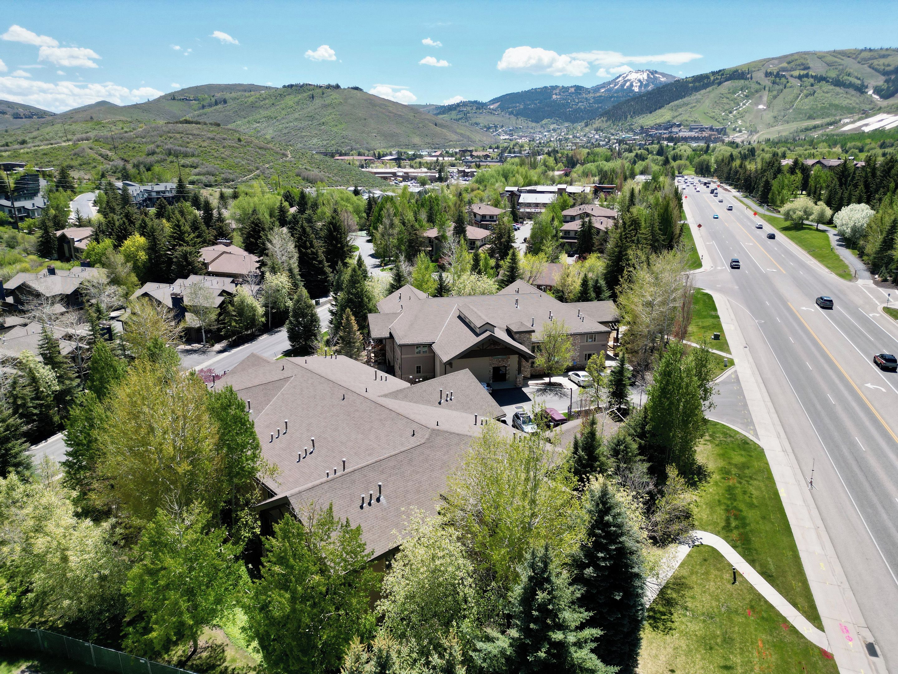 A residential area with houses, a road, and a mountain in the background.