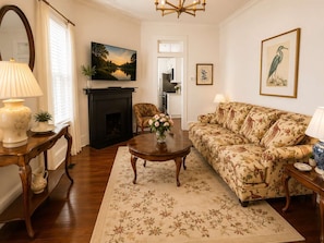 A living room with a fireplace, a sofa, a coffee table, and a television.