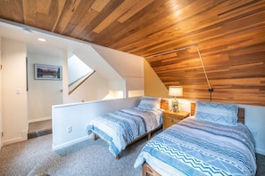 A bedroom with two beds, wooden ceiling, a nightstand, a lamp, and a picture on the wall. - Payday by All Seasons Resort Lodging (Park City)