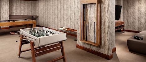 Une pièce équipée d’un baby-foot, d’une table de billard et d’un téléviseur.