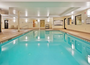 A large indoor swimming pool with clear water, surrounded by beige walls and a tiled floor. - Accessible 1BR Suite w/ Daily Hot Breakfast & Pool (Reno)