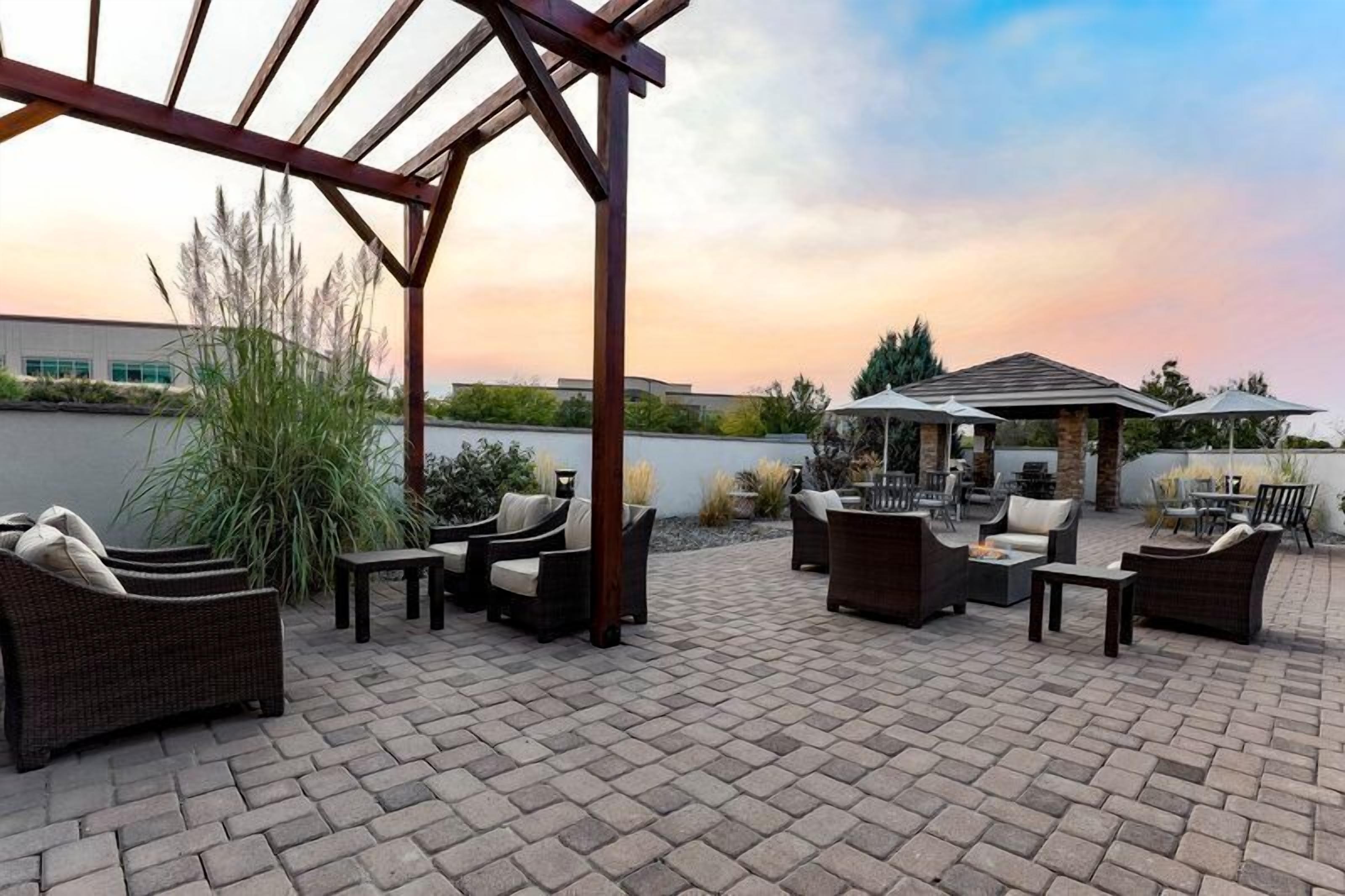 An outdoor patio area with wicker furniture and a pergola structure.