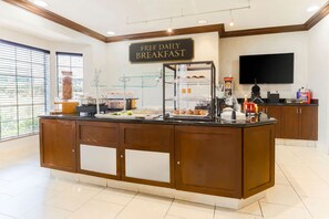 A breakfast station with a sign that reads 'FREE DAILY BREAKFAST'.
