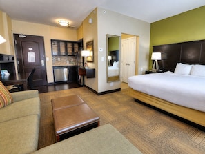Une chambre d’hôtel comprenant un lit, un bureau, une kitchenette et une salle de bain.