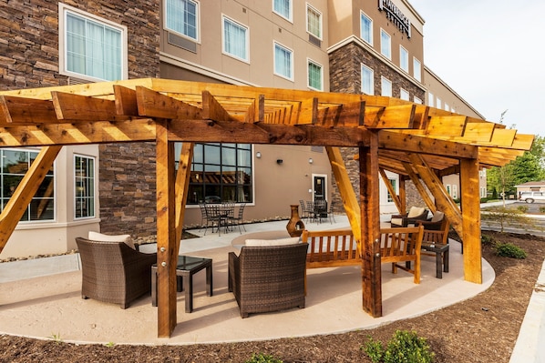 Pergola with lounge seating on the outdoor patio — a good spot to catch some sun between meals