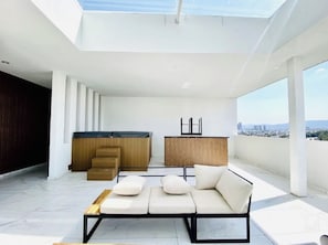 A modern living space with a sofa, a wooden cabinet, and a view of the city. - Agave House | panoramic view | near Andares and hospitals (Zapopan)
