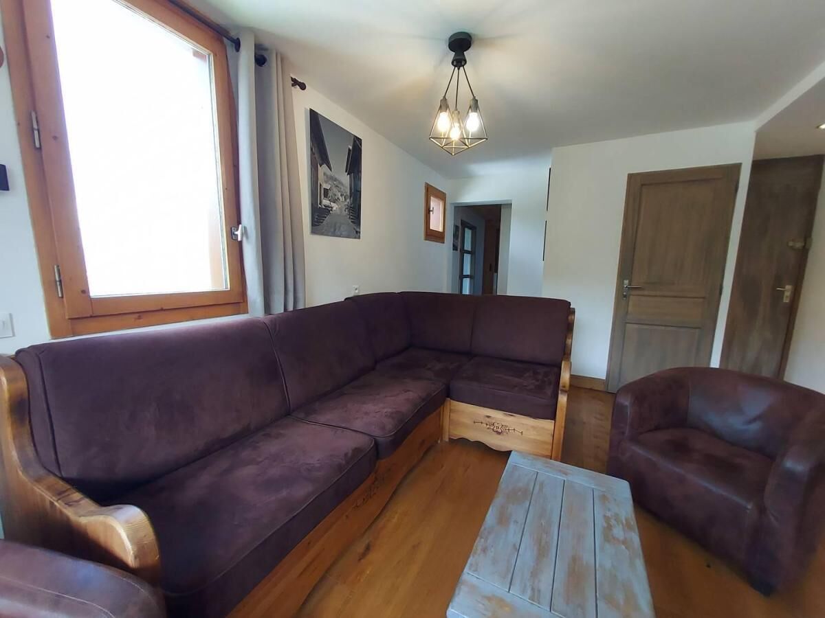 A living room with a sectional sofa, a coffee table, and a wooden floor.