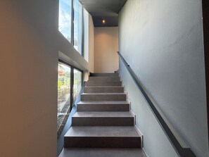 A staircase with a handrail, leading to an upper floor. - CasaRipa, one-bedroom apartment with olive grove view, 5 minutes from the lake (Riva del Garda)