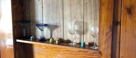 A wooden shelf with decorative glassware and a tissue box.