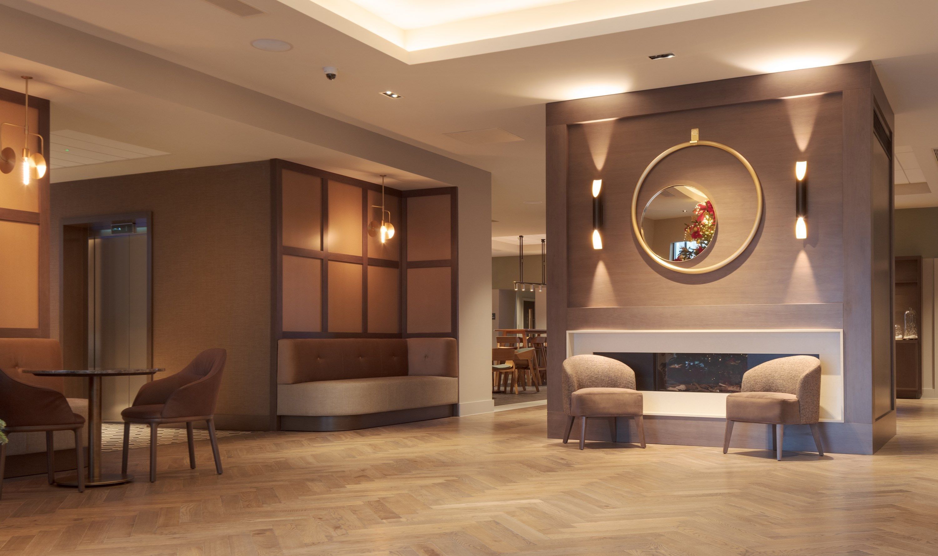 A modern lobby with a fireplace, seating area, and a reception desk.