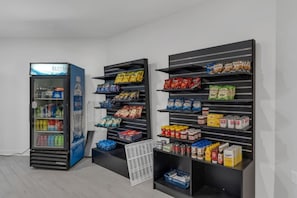 Ein Getränkeautomat und Regale voller Snacks und Getränke.