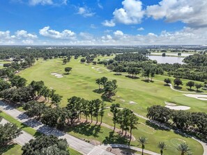 A golf course with sand bunkers, trees, and a clear sky. - King Bed Escape 7 min to Disney + Pool (Kissimmee)