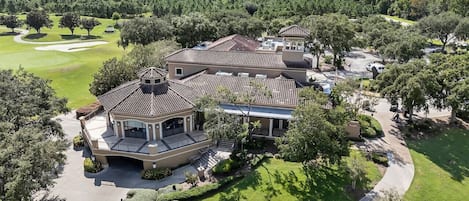 Una extensa propiedad con varias edificaciones, un campo de golf y un lago al fondo.