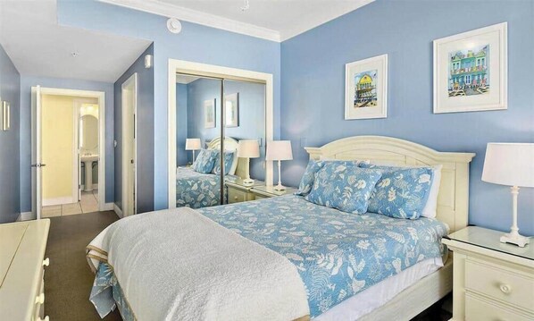 A bedroom with a large bed, bedside tables, a mirror, and artwork on the wall. - 2 Belmont Oceanfront Condos Boardwalk Pool Gym (Ocean City)
