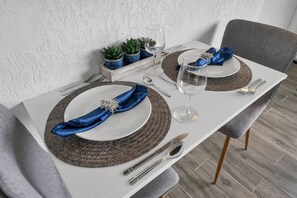 A dining table set with plates, napkins, cutlery, and a glass of water. - Whimsical Study 7 min to Disney Pool & FreeParking (Kissimmee)
