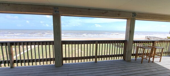 Una terraza de madera con vista al océano.