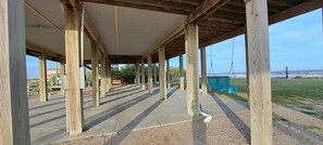 An outdoor covered area with wooden beams and a view of the ocean. - Beachfront House - Sunny Beach Retreat (Gilchrist)