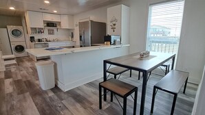 Una cocina moderna con una isla central, electrodomésticos integrados y un comedor con bancos.