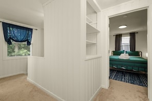 A room with a window, a bed, and a door leading to another room. - Rockne Retreat<>6BR 3BA Home Close to ND (South Bend)