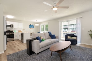 A modern living room with a sofa, coffee table, and a ceiling fan.