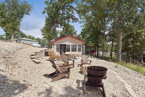 A cabin with a gravel patio, outdoor seating, and a barbecue grill. - 3 Bedroom 2 Bath Home with Lake Views (Sunrise Beach)