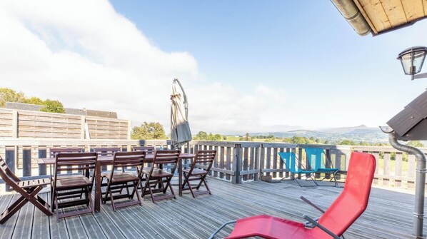 A deck with wooden furniture, including chairs and a table, overlooking a scenic landscape. - The Sancy - SAINT SAUVES D'AUVERGNE (SAINT SAUVES D'AUVERGNE)