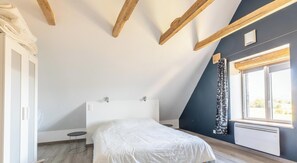 A bedroom with a bed, a window with curtains, and a radiator. - The Sancy - SAINT SAUVES D'AUVERGNE (SAINT SAUVES D'AUVERGNE)