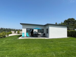 Una casa moderna con patio, un tavolo da pranzo e due sedie.