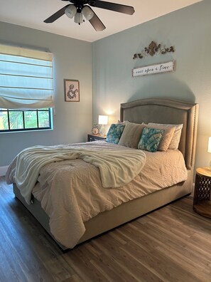 A bedroom with a bed, a nightstand, a wall clock, a ceiling fan, and a window with blinds. - OLE’ Lely resort. Beautiful 3-bedroom 2.5 bath townhome. Resort-style living! (Naples)
