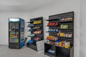 Ein Getränkeautomat und Regale voller Snacks und Erfrischungen.