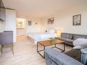 Ein modernes Wohnzimmer mit Bett, Sofa und Couchtisch.
