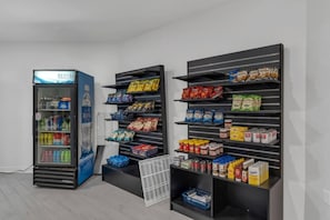 A vending machine and shelves stocked with snacks and beverages. - Cozy King Suite 7 Min from Disney + Parking | Orl (Kissimmee)