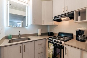 Una cocina moderna con estufa a gas, cafetera y tostadora.